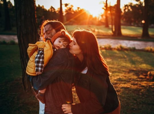 woman in brown long sleeve shirt carrying girl in white shirt