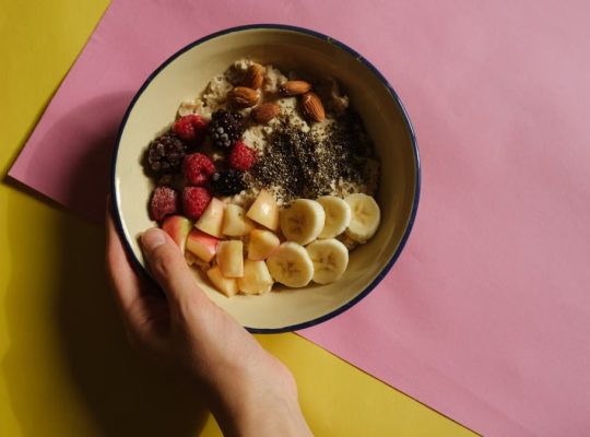 A vibrant oatmeal bowl with fruits and nuts on a pastel background, perfect for healthy breakfast ideas.