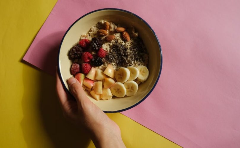 A vibrant oatmeal bowl with fruits and nuts on a pastel background, perfect for healthy breakfast ideas.